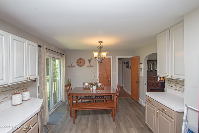 33 Woodside Dr, Glenville, NY 12302 - dining space with arched walkways, light wood-style flooring, and a chandelier