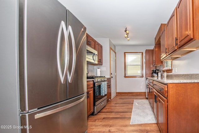 23 Mcmillen Pl, Bethlehem, NY 12054 - kitchen with stainless steel appliances, light wood finished floors, light countertops, and brown cabinets