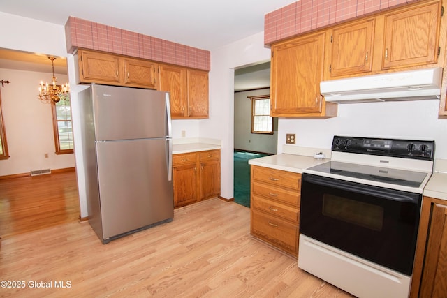 66 Via Da Vinci, Clifton Park, NY 12065 - kitchen featuring electric range oven, freestanding refrigerator, under cabinet range hood, a chandelier, and light wood-type flooring