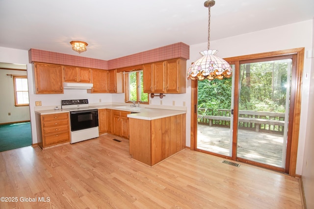 66 Via Da Vinci, Clifton Park, NY 12065 - kitchen with white electric stove, under cabinet range hood, light countertops, light wood finished floors, and decorative light fixtures