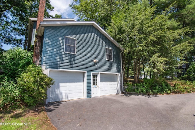 66 Via Da Vinci, Clifton Park, NY 12065 - view of side of property featuring a chimney, driveway, and a garage