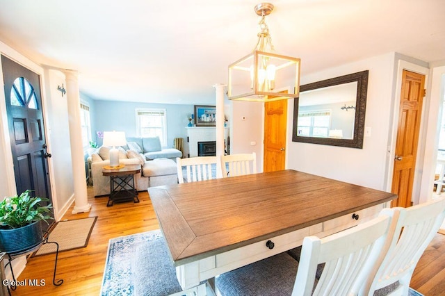 1264 Pilot Knob Rd, Fort Ann, NY 12844 - dining area with ornate columns, light wood-style floors, and a glass covered fireplace