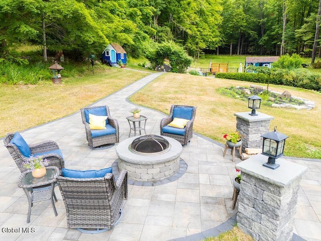 1264 Pilot Knob Rd, Fort Ann, NY 12844 - view of patio / terrace with a fire pit, an outbuilding, and a wooded view