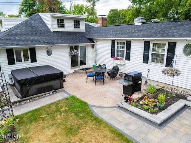 1264 Pilot Knob Rd, Fort Ann, NY 12844 - back of house with a hot tub, a patio area, roof with shingles, a chimney, and a lawn