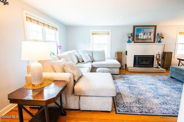 1264 Pilot Knob Rd, Fort Ann, NY 12844 - living area with radiator heating unit, wood finished floors, and a brick fireplace