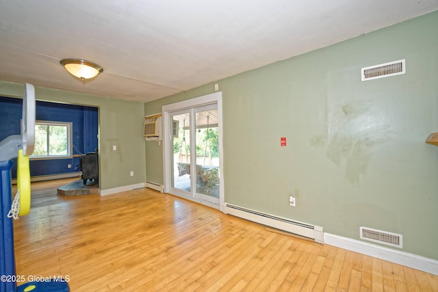 962 Camden Valley Rd, Salem, NY 12873 - empty room featuring baseboard heating, hardwood / wood-style flooring, and a wood stove