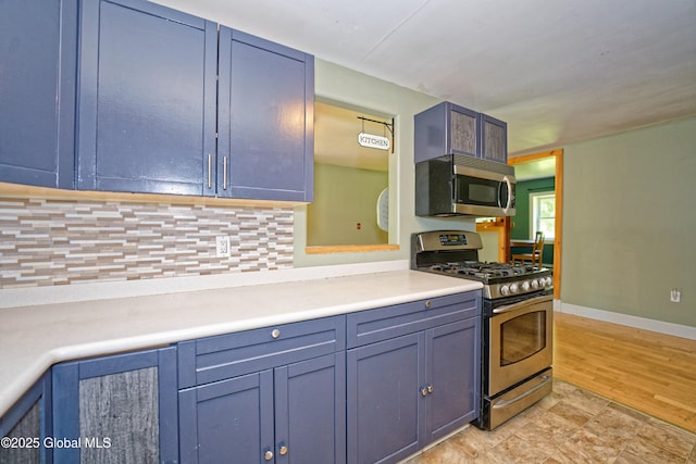 962 Camden Valley Rd, Salem, NY 12873 - kitchen with stainless steel appliances, tasteful backsplash, light countertops, blue cabinetry, and light wood finished floors