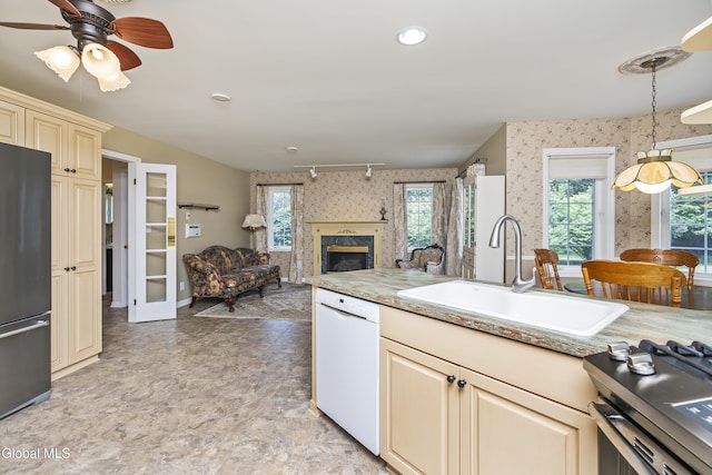 1 Maple Dr, Greenfield, NY 12833 - kitchen with white dishwasher, freestanding refrigerator, wallpapered walls, cream cabinetry, and a fireplace