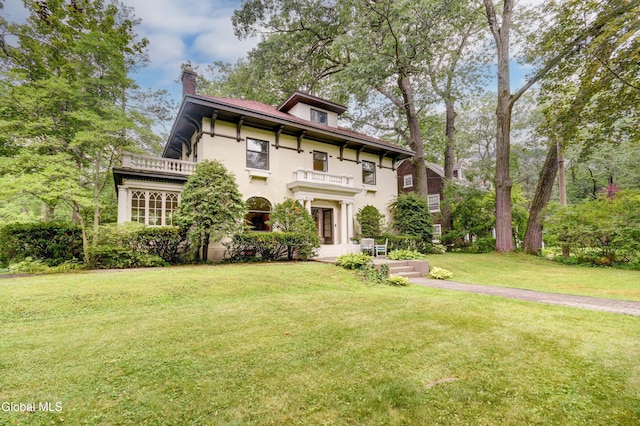 1171 Lowell Rd, Schenectady, NY 12308 - italianate home featuring a balcony, a chimney, a front lawn, and stucco siding