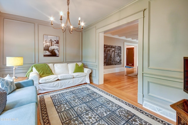 1171 Lowell Rd, Schenectady, NY 12308 - living area with a decorative wall, a chandelier, light wood-type flooring, and ornamental molding