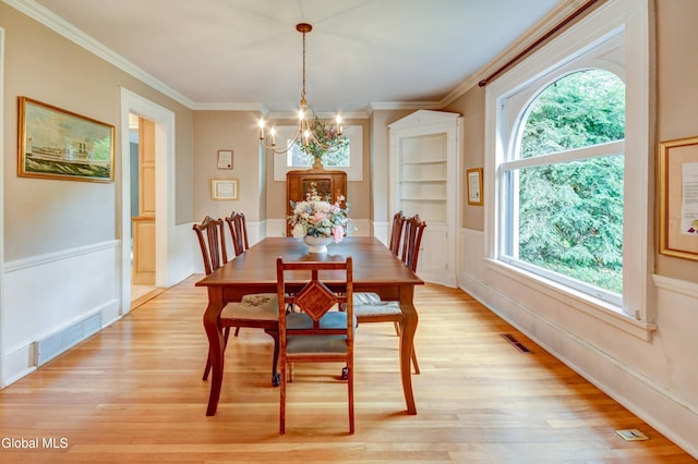 1171 Lowell Rd, Schenectady, NY 12308 - dining room with a chandelier, light wood-style flooring, crown molding, and a wainscoted wall