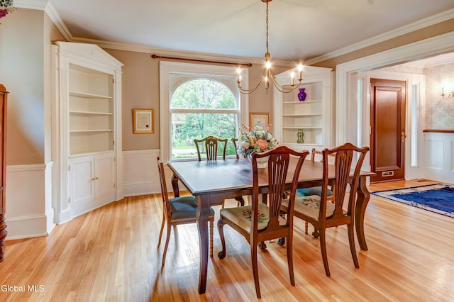 1171 Lowell Rd, Schenectady, NY 12308 - dining area featuring a chandelier, light wood-style flooring, wainscoting, ornamental molding, and built in shelves