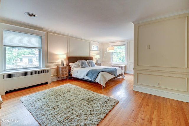 1171 Lowell Rd, Schenectady, NY 12308 - bedroom with radiator, a decorative wall, light wood finished floors, and crown molding