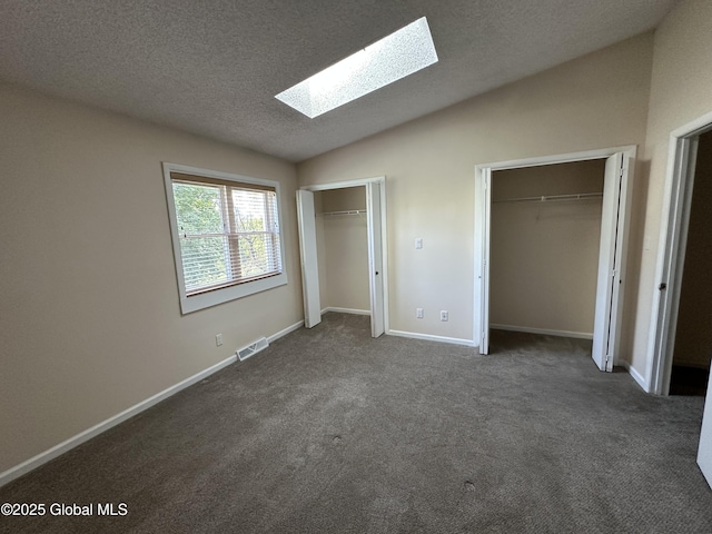 11 Derby Dr, Saratoga Springs, NY 12866 - unfurnished bedroom featuring a skylight, two closets, vaulted ceiling, dark colored carpet, and a textured ceiling