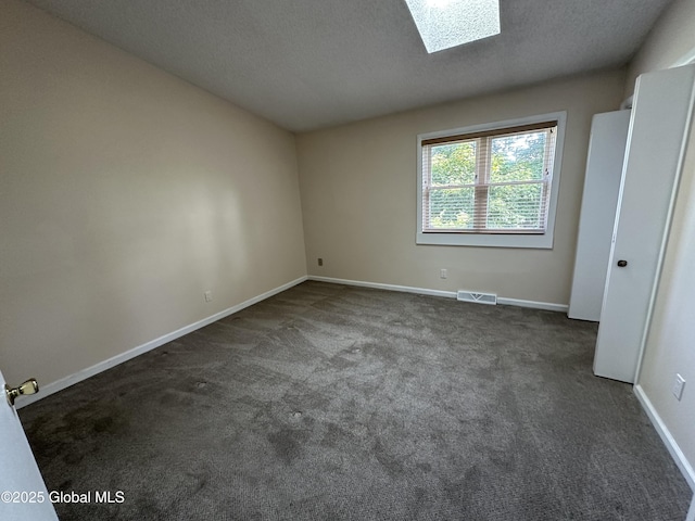 11 Derby Dr, Saratoga Springs, NY 12866 - spare room featuring dark carpet, a textured ceiling, and a skylight