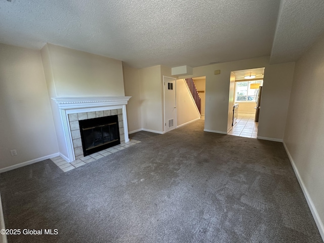 11 Derby Dr, Saratoga Springs, NY 12866 - unfurnished living room featuring a textured ceiling, a tile fireplace, and carpet flooring