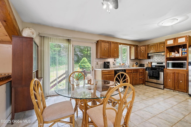 1927 Berne Altamont Rd, Altamont, NY 12009 - kitchen with stainless steel appliances, brown cabinetry, decorative backsplash, and light countertops