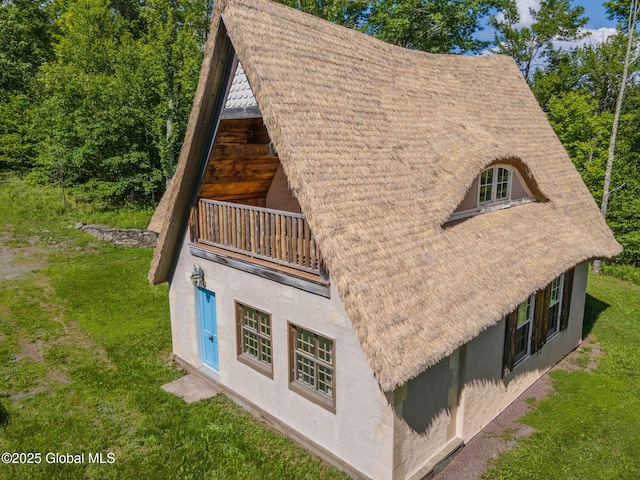 372 Jones Hill Rd, Jefferson, NY 12093 - view of side of property featuring stucco siding, a balcony, and a lawn