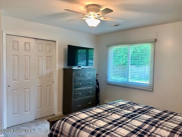 2059 Rosedale Way, Guilderland, NY 12303 - bedroom with a closet, light carpet, and a ceiling fan