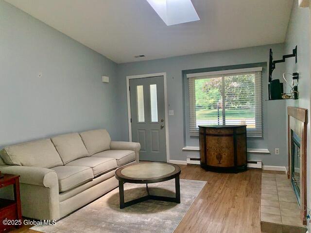 2059 Rosedale Way, Guilderland, NY 12303 - living room featuring wood finished floors, baseboard heating, and a skylight