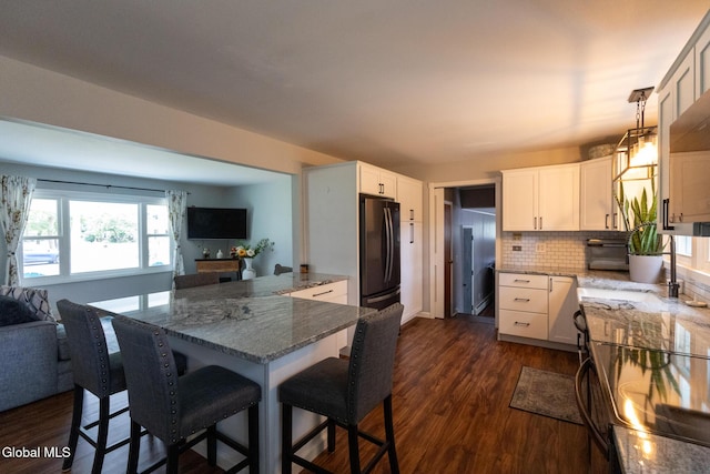 7 Shady Gln, Clifton Park, NY 12019 - kitchen with freestanding refrigerator, open floor plan, a breakfast bar, and stone counters