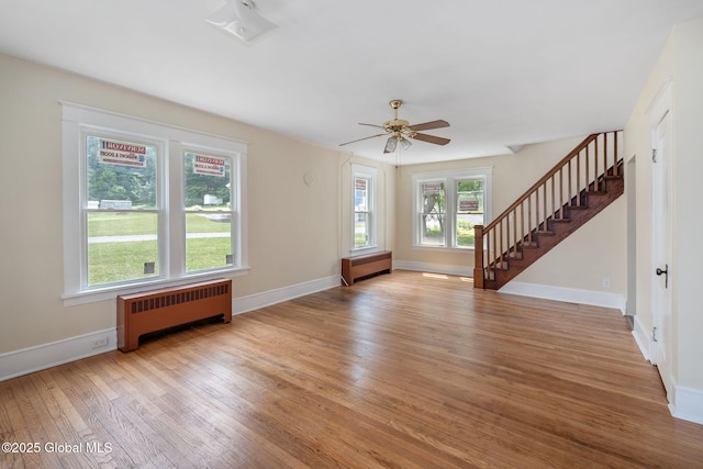 1707 Helderberg Trl, Berne, NY 12023 - unfurnished living room featuring radiator, hardwood / wood-style floors, stairway, and a ceiling fan