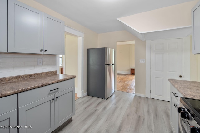 1707 Helderberg Trl, Berne, NY 12023 - kitchen with appliances with stainless steel finishes, backsplash, light wood finished floors, and dark countertops