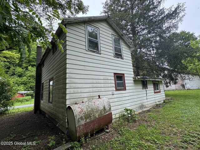 114 State Route 146, Wright, NY 12157 - view of home's exterior with oil tank, a lawn, and a chimney