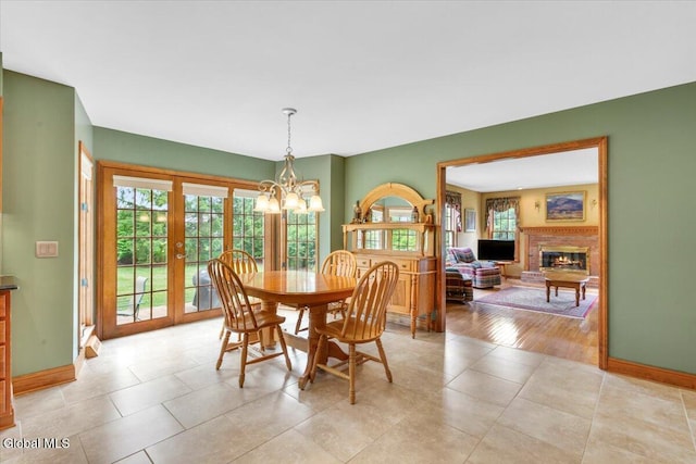 630 Salvia Ln, Guilderland, NY 12303 - dining room with a chandelier, plenty of natural light, a fireplace, and light tile patterned floors