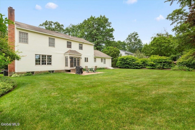 630 Salvia Ln, Guilderland, NY 12303 - rear view of house featuring a yard, a patio, entry steps, and a chimney