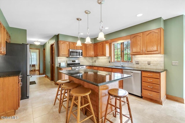 630 Salvia Ln, Guilderland, NY 12303 - kitchen with stainless steel appliances, a kitchen breakfast bar, tasteful backsplash, a center island, and decorative light fixtures