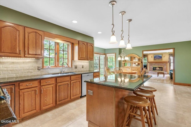 630 Salvia Ln, Guilderland, NY 12303 - kitchen featuring dishwasher, a kitchen island, decorative backsplash, a breakfast bar, and healthy amount of natural light