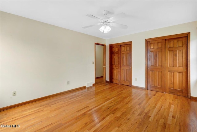 630 Salvia Ln, Guilderland, NY 12303 - unfurnished bedroom with two closets, light wood-style flooring, and ceiling fan