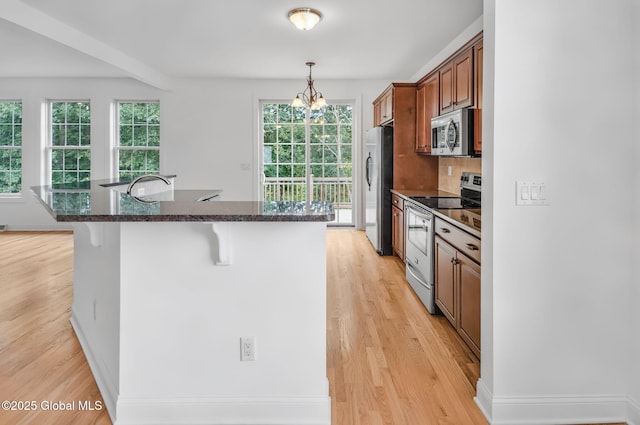 21 Beacon Dr, Colonie, NY 12189 - kitchen featuring appliances with stainless steel finishes, a breakfast bar, and light wood-type flooring