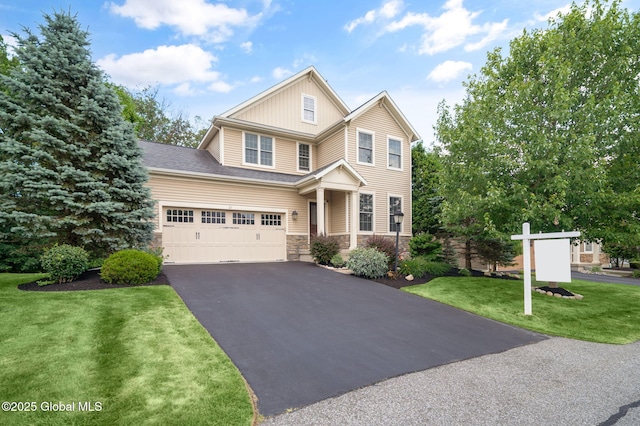 21 Beacon Dr, Colonie, NY 12189 - view of front facade with stone siding, asphalt driveway, a front yard, a garage, and board and batten siding