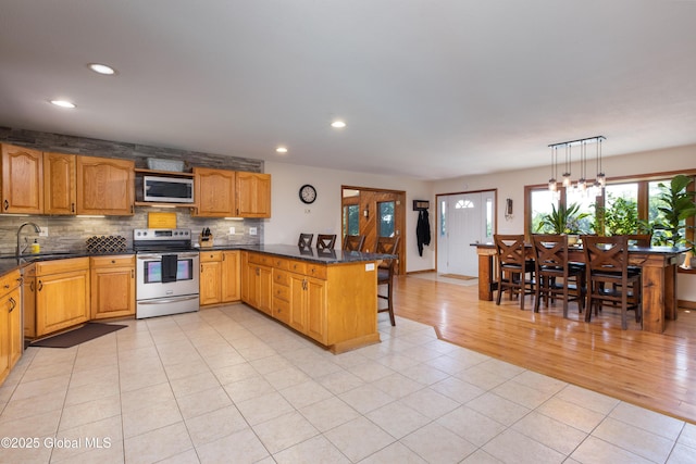 345 Goodman Rd, Fort Ann, NY 12827 - kitchen featuring appliances with stainless steel finishes, a peninsula, a breakfast bar, recessed lighting, and decorative backsplash