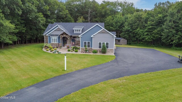 2794 W Lydius St, Schenectady, NY 12306 - craftsman-style house featuring stone siding, a front yard, covered porch, and a storage unit