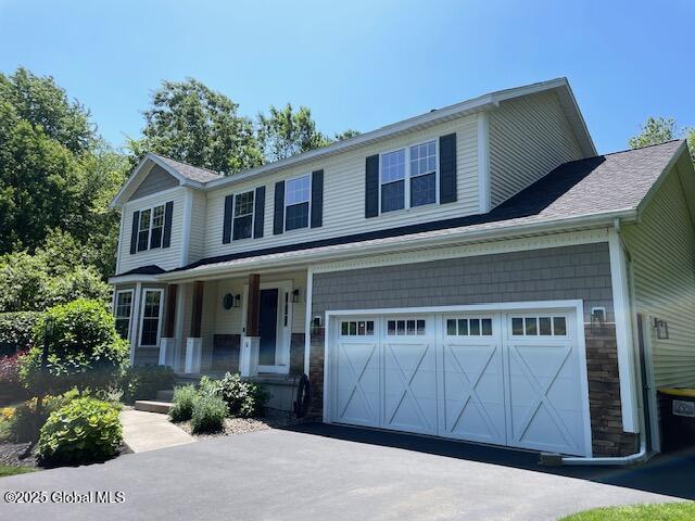 6 Patroon Way, Halfmoon, NY 12065 - view of front of home featuring a porch, an attached garage, stone siding, and asphalt driveway