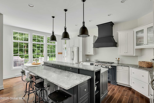 13 Bridlewood Loop, Clifton Park, NY 12148 - kitchen with stainless steel appliances, a kitchen island, custom exhaust hood, white cabinets, and recessed lighting
