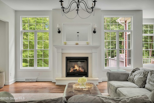 13 Bridlewood Loop, Clifton Park, NY 12148 - living room featuring a chandelier, wood finished floors, and a glass covered fireplace