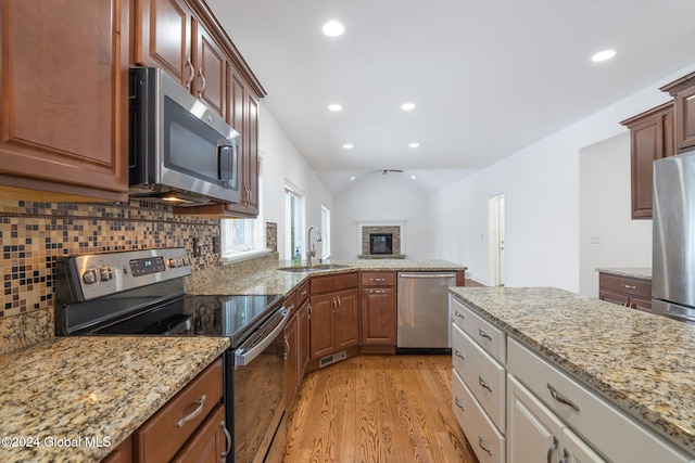13 Macory Way, Moreau, NY 12831 - kitchen with stainless steel appliances, light wood finished floors, decorative backsplash, vaulted ceiling, and recessed lighting