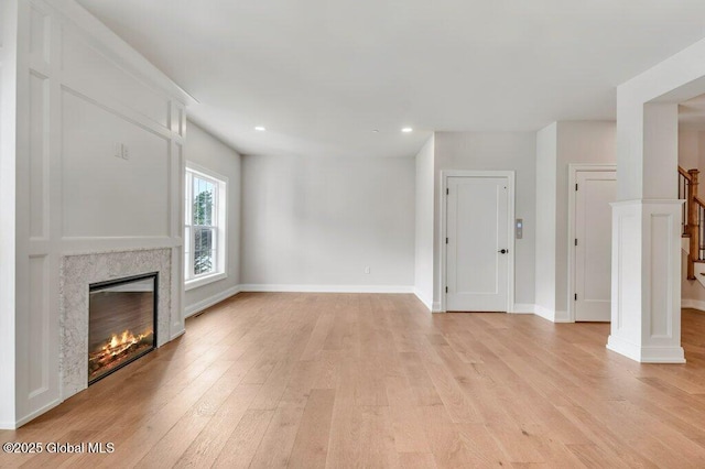 602 Vly Pointe Dr, Niskayuna, NY 12309 - unfurnished living room featuring light wood finished floors, a glass covered fireplace, recessed lighting, and stairway