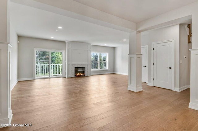 602 Vly Pointe Dr, Niskayuna, NY 12309 - unfurnished living room with a glass covered fireplace, light wood-style flooring, recessed lighting, and decorative columns