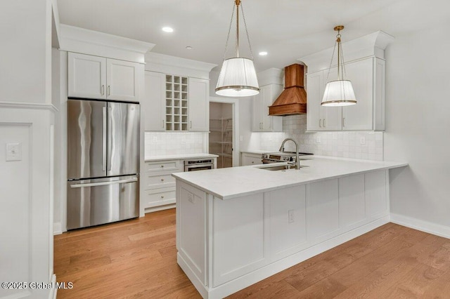 602 Vly Pointe Dr, Niskayuna, NY 12309 - kitchen featuring freestanding refrigerator, custom exhaust hood, light countertops, a peninsula, and tasteful backsplash