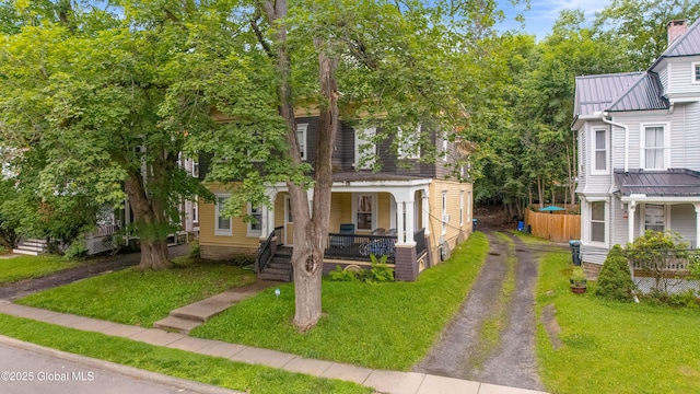31 Cedar St, Oneonta, NY 13820 - view of front facade featuring covered porch, driveway, a front lawn, and a metal roof