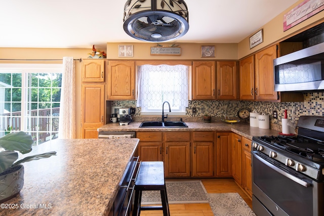 99 Fiddlers Ln, Colonie, NY 12110 - kitchen with appliances with stainless steel finishes, healthy amount of natural light, light wood-style floors, and tasteful backsplash