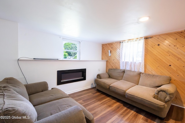 99 Fiddlers Ln, Colonie, NY 12110 - living area with wooden walls, a glass covered fireplace, wood finished floors, and an accent wall