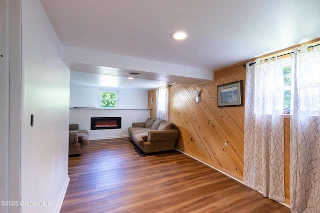 99 Fiddlers Ln, Colonie, NY 12110 - living room featuring a glass covered fireplace, wood finished floors, wooden walls, and recessed lighting