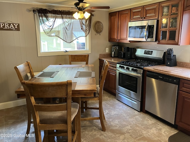 56 Pershing Dr, Scotia, NY 12302 - kitchen featuring appliances with stainless steel finishes, ceiling fan, glass insert cabinets, and light stone finish flooring