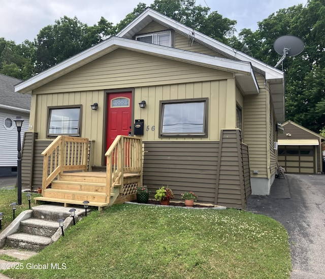 56 Pershing Dr, Scotia, NY 12302 - view of front of property featuring an outdoor structure, a front lawn, a detached garage, and board and batten siding